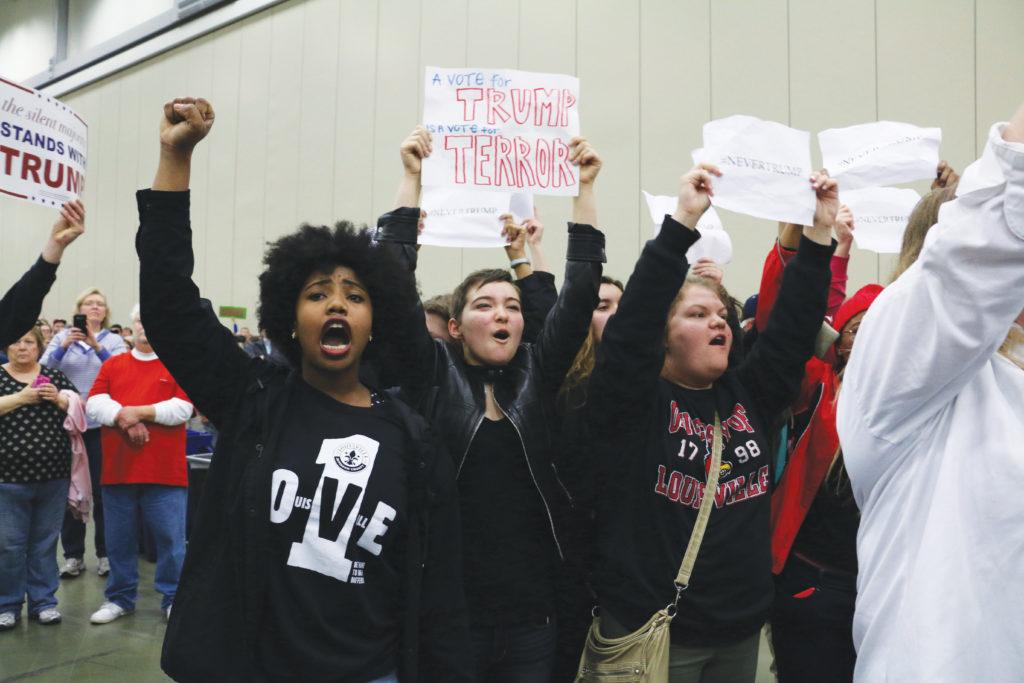 Louisville Youth Against Trump - Mia Thompson (18, Manual) protest Trump and his supporters at the rally on Match 1. I was nervous once we started because everyone was looking and starting to jeer. Then, everyone got into it and started cheering. It felt really great, especially as we got escorted out, Mura said. Photo creditL Hannah Phillips