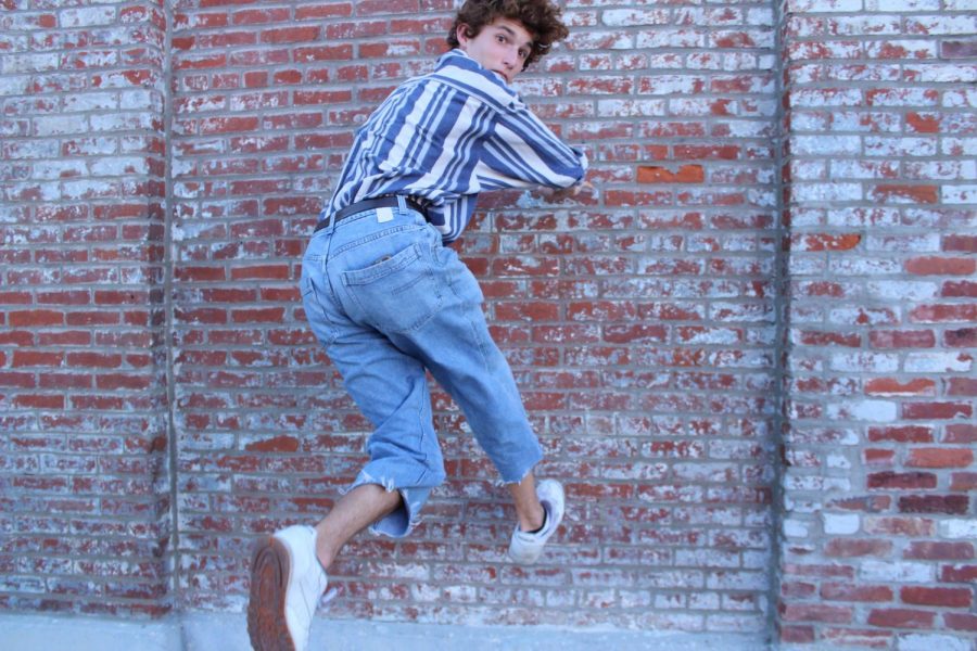 Senior Patrick Harper poses in front of a brick wall.