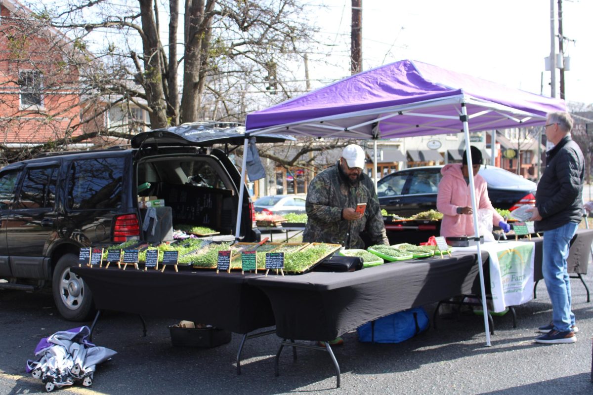 All done!: A vendor checks out a customer at the Bardstown Road Farmers’ Market on Feb 25. Photo by Anna Burzynski.