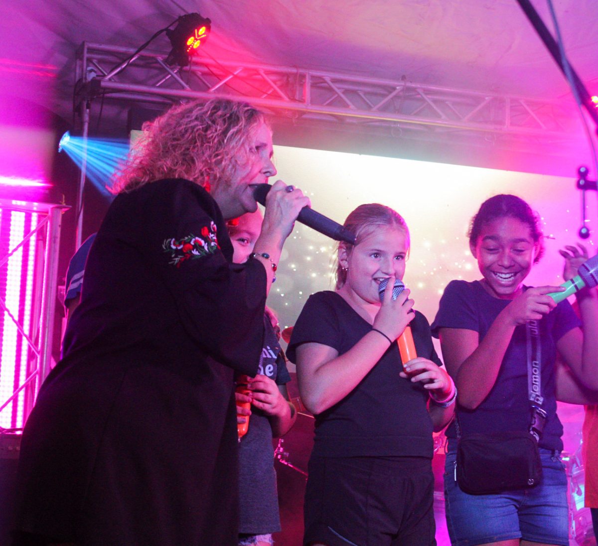 Interactive: Lead singer Mary Beth Vanmeter sings the songs vocals as she instructs young audience members Elyse and Ava (left to right) on Saturday Oct. 12 2024 at the Belknap Neighborhood Fall Festival. Photo by Sadie Eichenberger