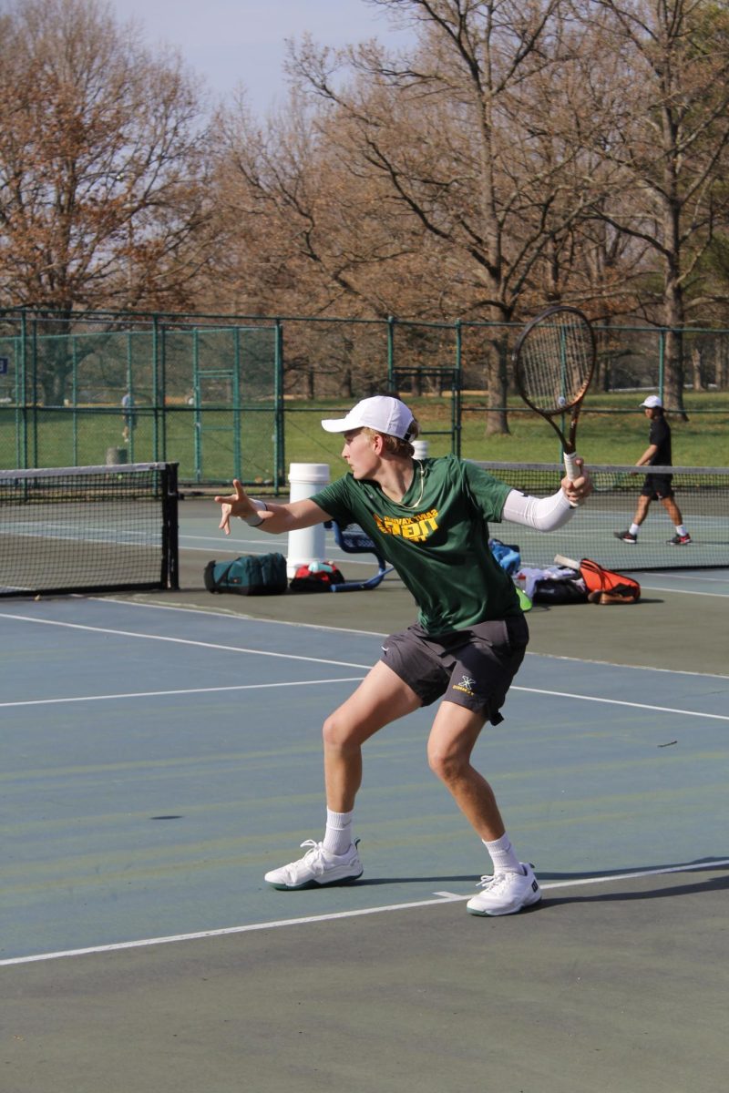 Serve It Up- Derek Abrams, 15, a freshman at St. Xavier High School, prepares to hit the ball during a tennis match against duPont Manual High School at Tom Sawyer Park on March 31. Abrams has been playing tennis since he was 4 years old, and he dreams of becoming a professional player.